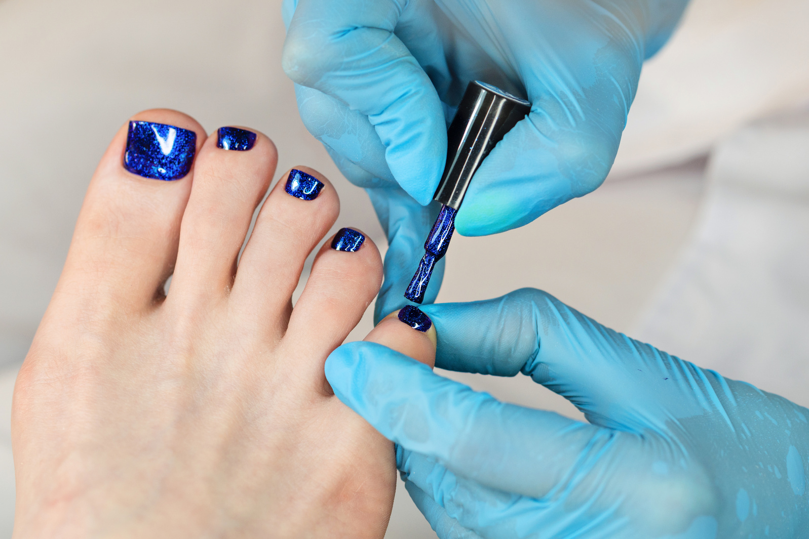Manicurist Applying Gel Nail Polish on Toenails